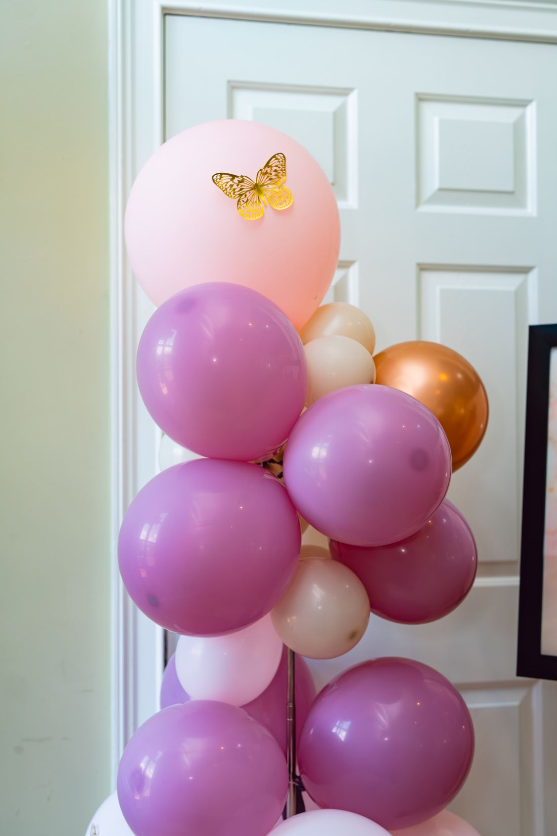 Balloon column in blush, lilac and gold finished with a gold butterfly