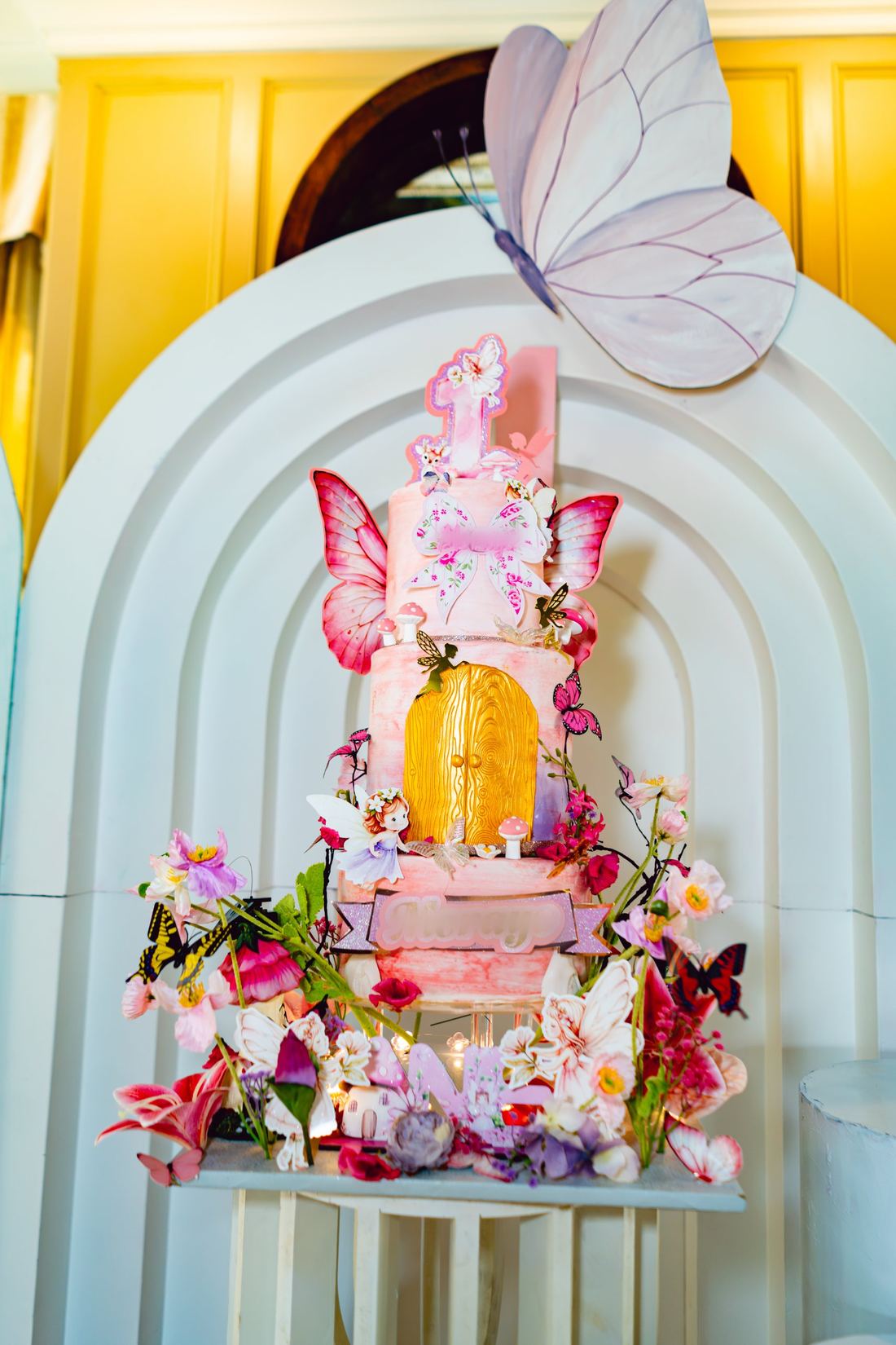 Three-tier hand-painted fairy cake with a gold door and sugar butterflies