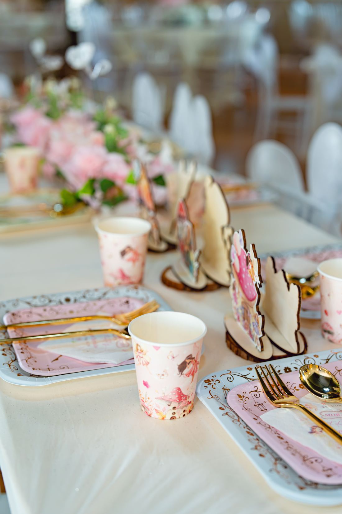 Fairy-print place setting with pink plates and gold cutlery