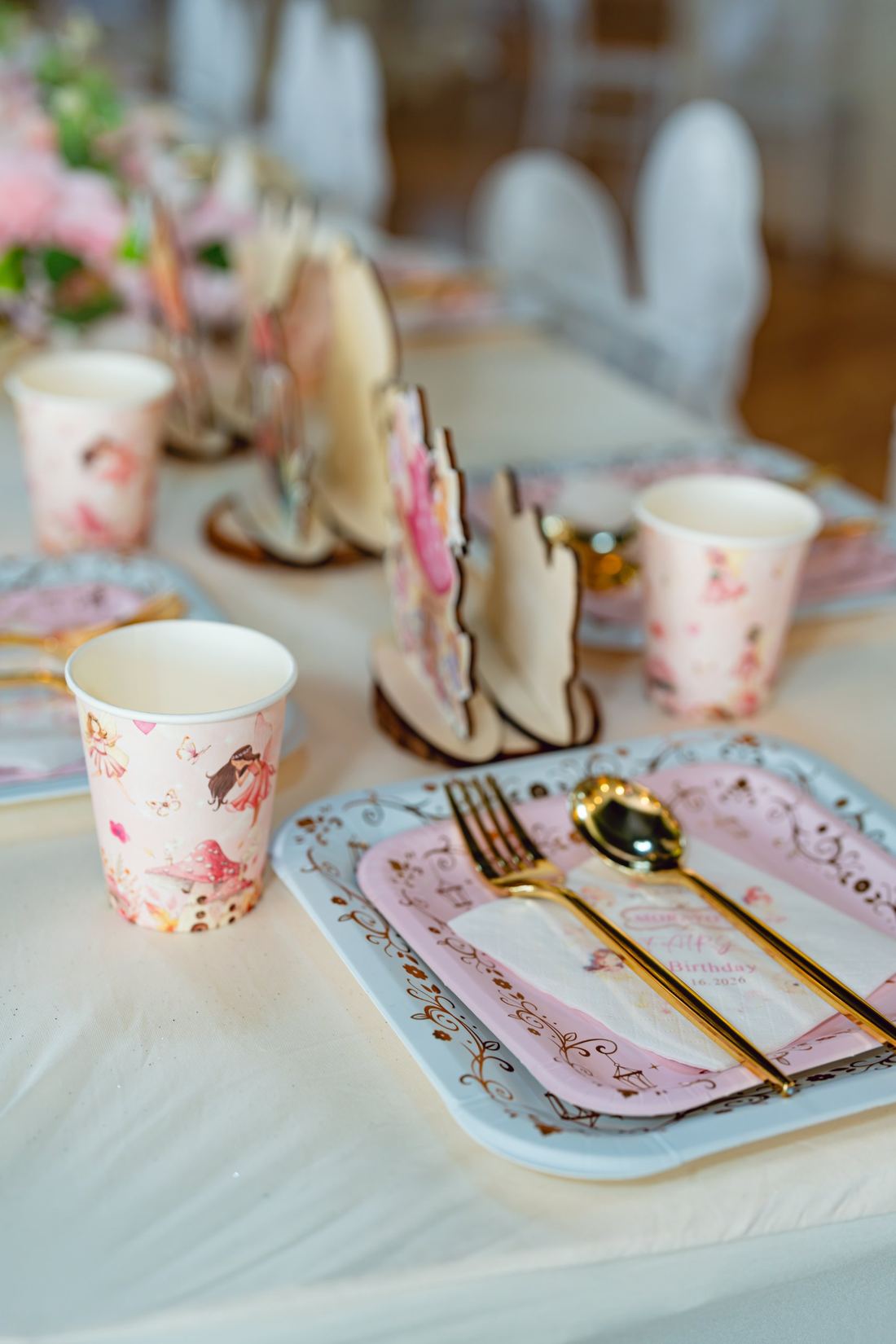 Fairy print cups and gold cutlery on a children's setting